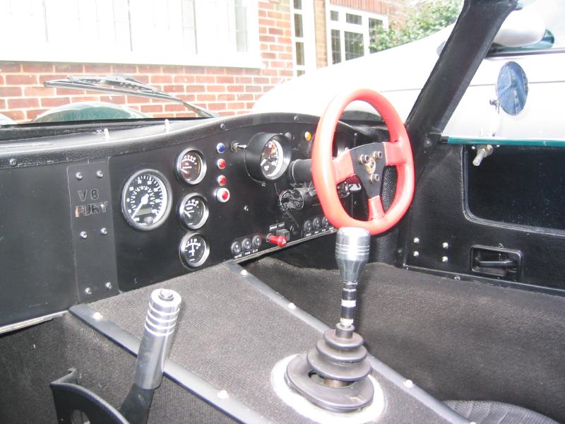 A car dashboard with some dials and random switches