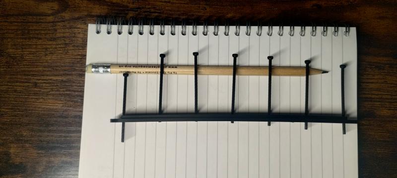 7 bolts wound through to different depths to mark a curve